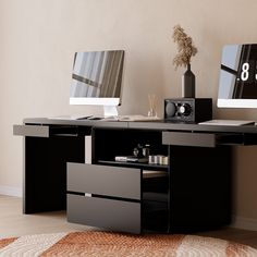 an office desk with two computers on it and a clock in the middle of the table