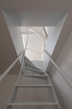 a white staircase leading up to the top floor in a room with no one on it