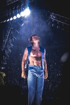 a shirtless man standing in front of a stage