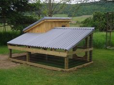 a chicken coop in the middle of a grassy field