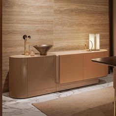 a room with a table, chairs and vases on the counter top in front of a wall