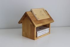 a small wooden house with a book on top