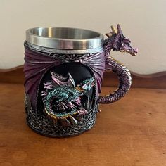 a purple dragon mug sitting on top of a wooden table