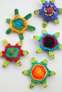 four turtle pinatas are shown on a white surface, one has an ornament in the center