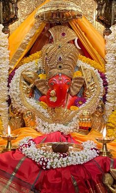 the statue of lord ganesh is surrounded by flowers and candles