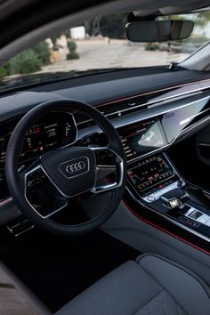 the interior of an audi car with red trims and steering wheel, dashboard, dash lights, and electronic controls