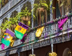 several flags hanging from the balcony of a building