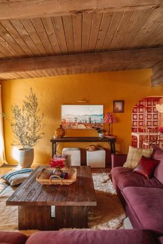 a living room with yellow walls and purple couches