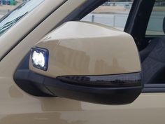 the side view mirror of a car with a cat on it's headlight