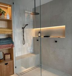 a bathroom with a walk in shower next to a shelf