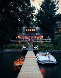 a boat is docked at the end of a dock with a house in the background