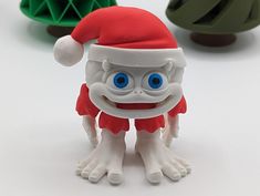 three plastic toys with blue eyes and white legs, one wearing a santa claus hat