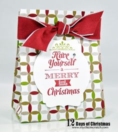 a christmas gift bag with a red bow on the top and merry message below it