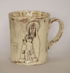 a ceramic mug with a drawing of jesus holding a child