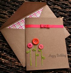 two brown envelopes with pink ribbon and button flowers on them, one has a happy birthday card