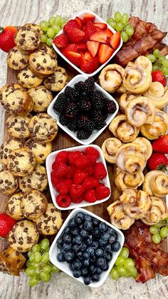 a platter filled with fruit and pastries on top of a wooden cutting board