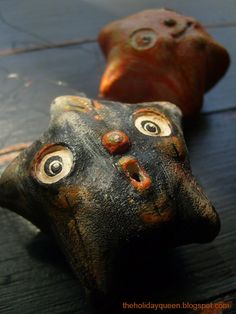 two clay heads with eyes on them sitting next to each other