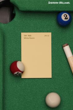 billiard's table with pool balls, cues and paper on green cloth