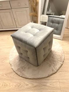 a white ottoman sitting on top of a rug