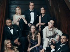 a group of people in tuxedos sitting on stairs