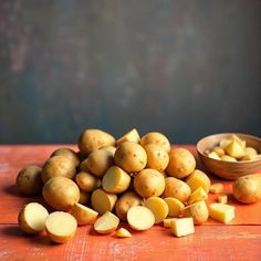 potatoes are piled on top of each other next to a bowl