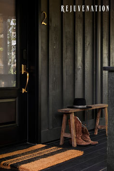 a wooden bench sitting in front of a black door