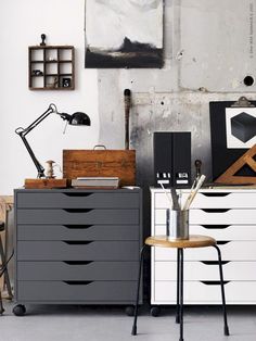 a white dresser sitting next to a black and white chest of drawers