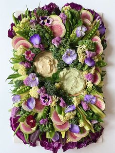 an arrangement of flowers arranged in the shape of a circle with dip and sauce on top