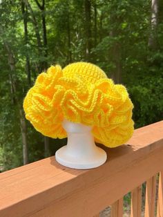 a yellow knitted hat sitting on top of a white mannequin's head