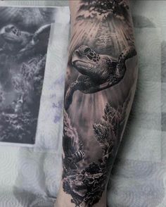 a man's arm with a turtle and corals on it, in black and white