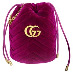 Introducing the Gucci GG Marmont Mini Velvet Bucket Bag – a luxurious and stylish accessory that exudes sophistication and elegance. Crafted from soft velvet in a rich raspberry purple hue, this shoulder bag is a statement piece that adds a pop of color to any ensemble. The bag features an adjustable gold-tone chain crossbody strap, allowing for versatile styling options. The gold-tone Gucci GG logo on the front adds a touch of glamour and luxury to the design, while the open top reveals a satin fabric interior with a patch pocket for convenient storage of your essentials. The velvet exterior of the bag features an intricate quilted motif, adding texture and depth to the design. The whimsical heart on the back of the bag adds a playful touch and serves as the perfect finishing detail to th Gg Marmont Mini Bucket Bag, Velvet Gucci, Gucci Pouch, Gucci Gg Marmont Mini, Gg Marmont Mini, Whimsical Heart, Moschino Dress, Evening Accessories, Gucci Crossbody Bag