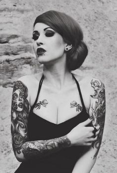 a black and white photo of a woman with tattoos