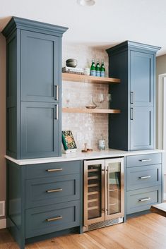 a kitchen with blue cabinets and wine glasses