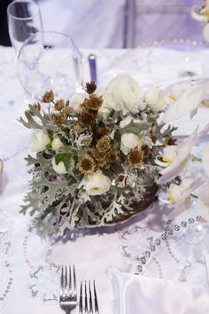 the table is set with silverware and flowers