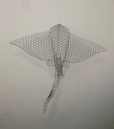 a wire sculpture is hanging on the wall