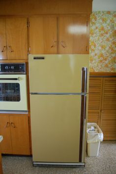 a yellow refrigerator freezer sitting inside of a kitchen