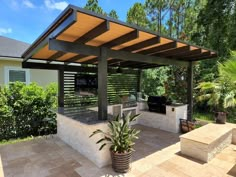 an outdoor kitchen with grill and seating area