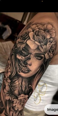 a woman's arm with flowers and skulls on her face, in black and white