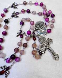 Immerse yourself in divine tranquility with our Angels of Heaven Rosary, a beautiful and spiritually uplifting piece designed for your prayer and reflection. Handcrafted with care, this rosary combines elegance and reverence, making it a perfect companion for your spiritual journey. Features: ✨Purple Amethyst Beads: Each bead is a rich, deep purple amethyst, renowned for its calming and protective properties. These 8mm beads bring a touch of luxury and spiritual significance to your prayers. ✨Pa Purple Beaded Rosary As Gift, Spiritual Rosary With 8mm Beads, Spiritual Gemstone Beads Rosary, Spiritual Rosary With 8mm Beads For Healing, Bohemian Rosary With Polished Beads As Gift, 108 Bead Cross Jewelry For Meditation, Spiritual Rosary With Polished Beads As Gift, Silver Spiritual Rosary For Healing, Bohemian Rosary With Natural Stones For Gifts