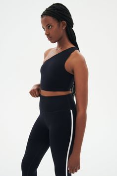 a woman wearing black and white sports bra with side stripe on the leggings