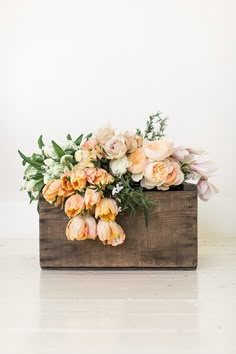 a wooden box filled with flowers on top of a table