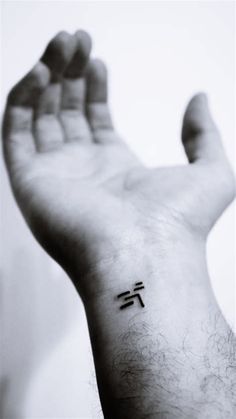 a person's hand with a small tattoo on it