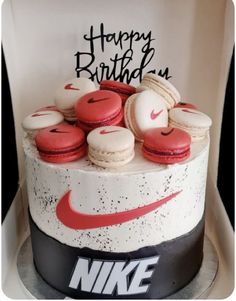 a birthday cake decorated with red and white macaroons