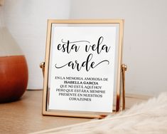 a sign that says esta vela arde on it next to a vase