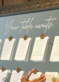 a woman pointing at a table with notes on it and coins in front of her