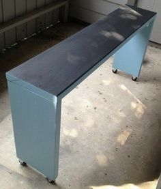 a long blue bench sitting on top of a cement floor next to a garage door