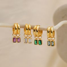 Introducing our elegant Dangling Gemstone Hoop Earrings, designed in gold finish with a unique twist - Removable Emerald-Cut Gemstones! These earrings blend classic charm with modern versatility, letting you create your own statement ✨ Material: High Quality Solid 925 Sterling Silver Finish: Sterling Silver ∙ 18K Gold Featuring minimalist ~15mm Hoop Earrings with Emerald-Cut, Removable ~7x5mm CZ Gemstones Sold as a Pair Part of our Birthstone Collection Final Sale SKU: RR-ER400 Gold Plated Dangle Hoop Earrings With Gemstones, Elegant Gemstone Dangle Hoop Earrings, Minimalist Gold Plated Gemstone Earrings, Emerald Gemstone Hoop Earrings In Yellow Gold, Green Gemstone Dangle Hoop Earrings, Emerald Cut Solitaire Ring, Initial Tag Necklace, Sideways Initial Necklace, Emerald Birthstone