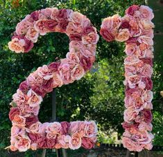 the letter p made out of flowers is displayed in front of a bush and trees