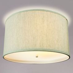 a light fixture with a white shade on the bottom and a green lining around it