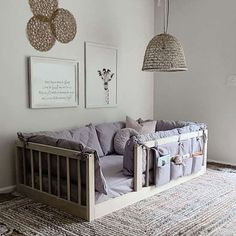 a baby crib in the corner of a room with pictures hanging on the wall